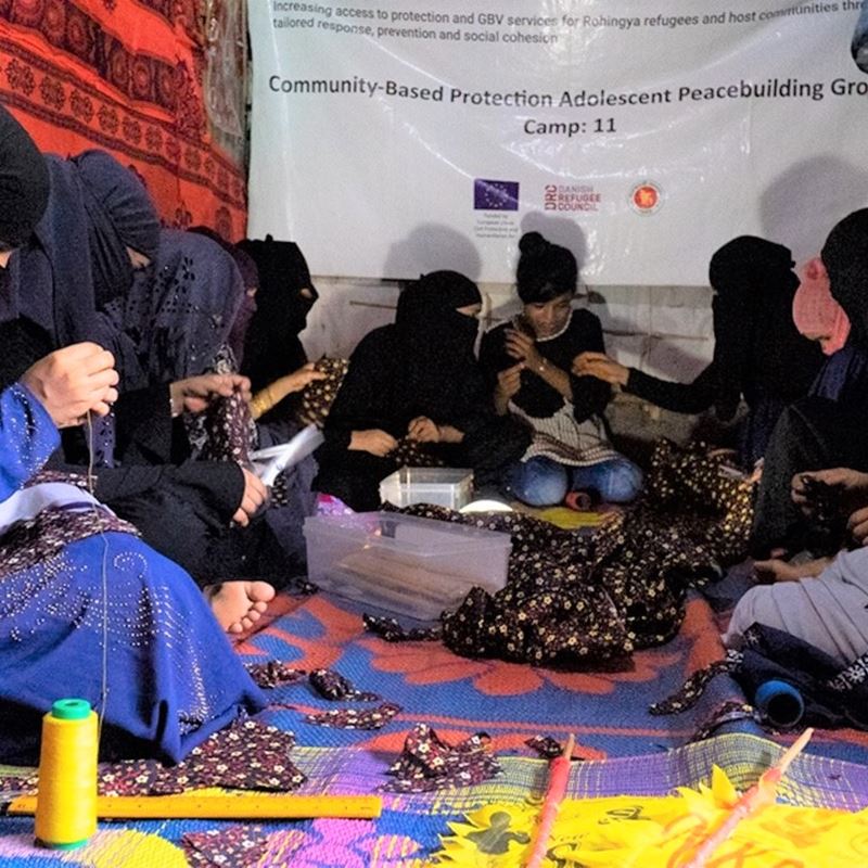 Gruppe af kvinder syer hygiejnebind i Camp 8W. Produktionsomkostningerne for hvert genanvendelige bind er kun 0,1 Euro. Sina Hasan / DRC Bangladesh
